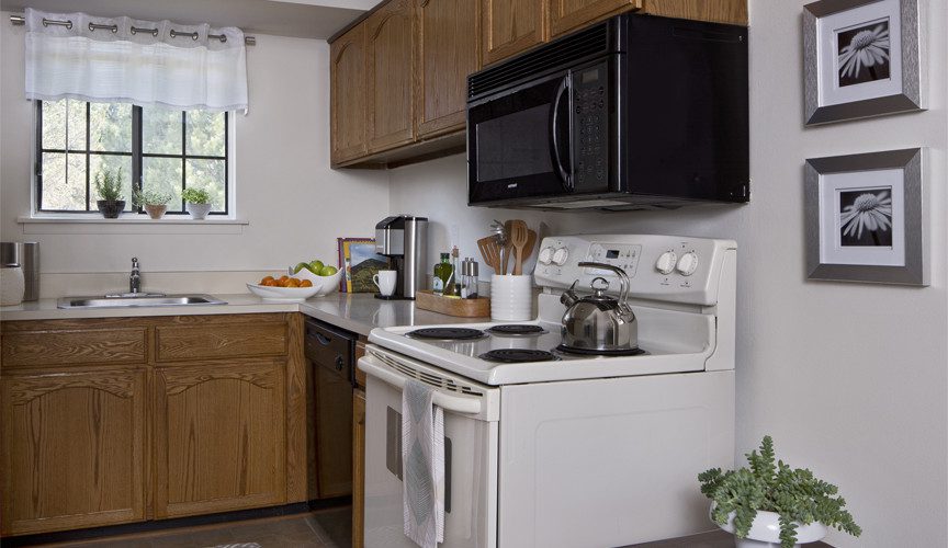 Kitchen with stove, microwave, and sink