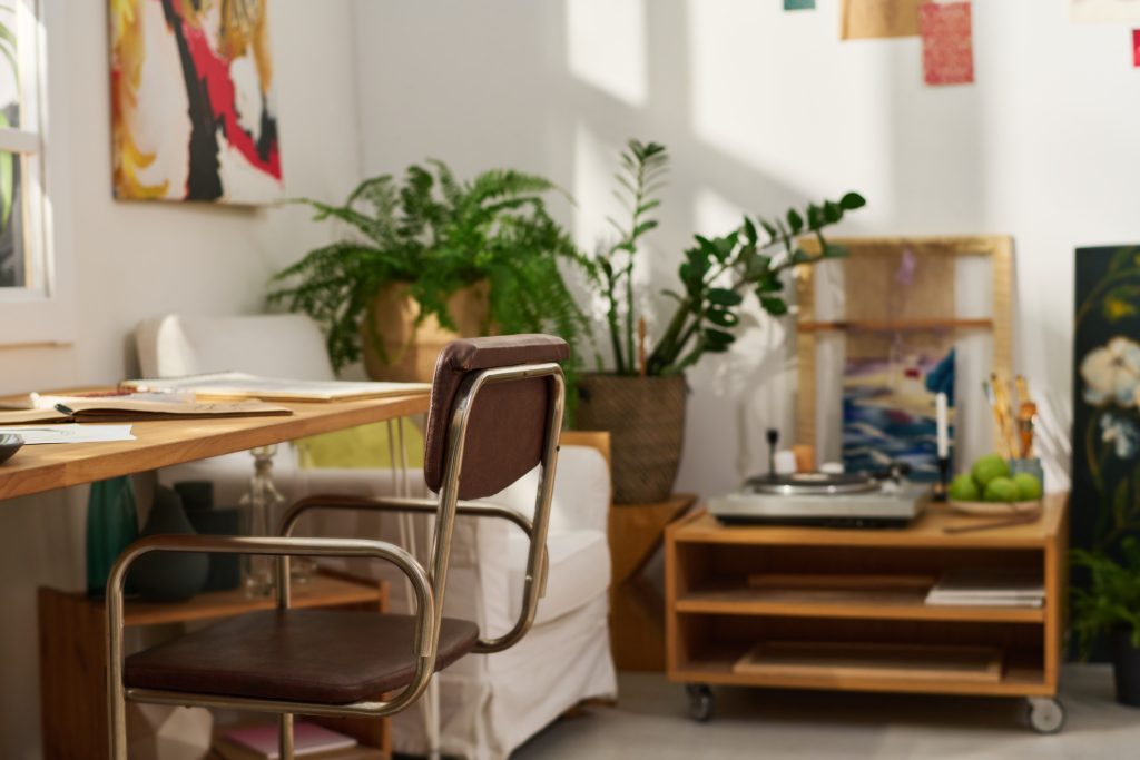 Apartment bedroom converted into a creative art workspace with supplies and desk.